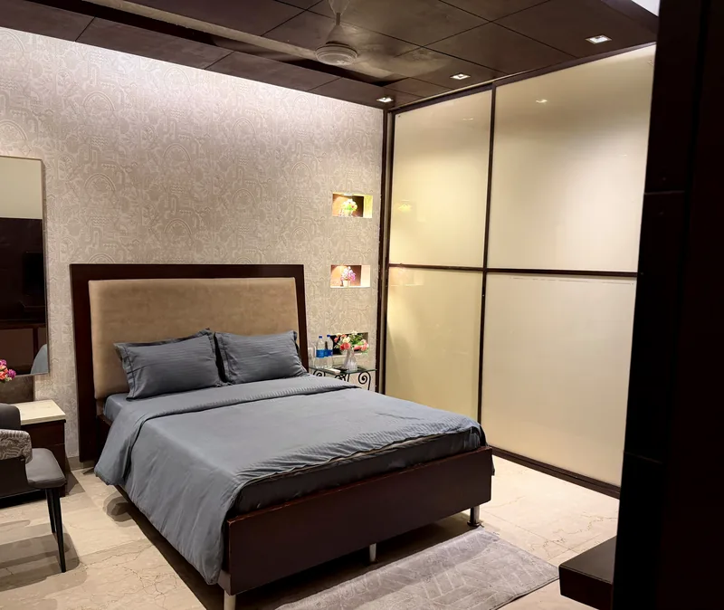 Bedroom with upholstered headboard, patterned feature wall and wardrobe at Nivasa Villas