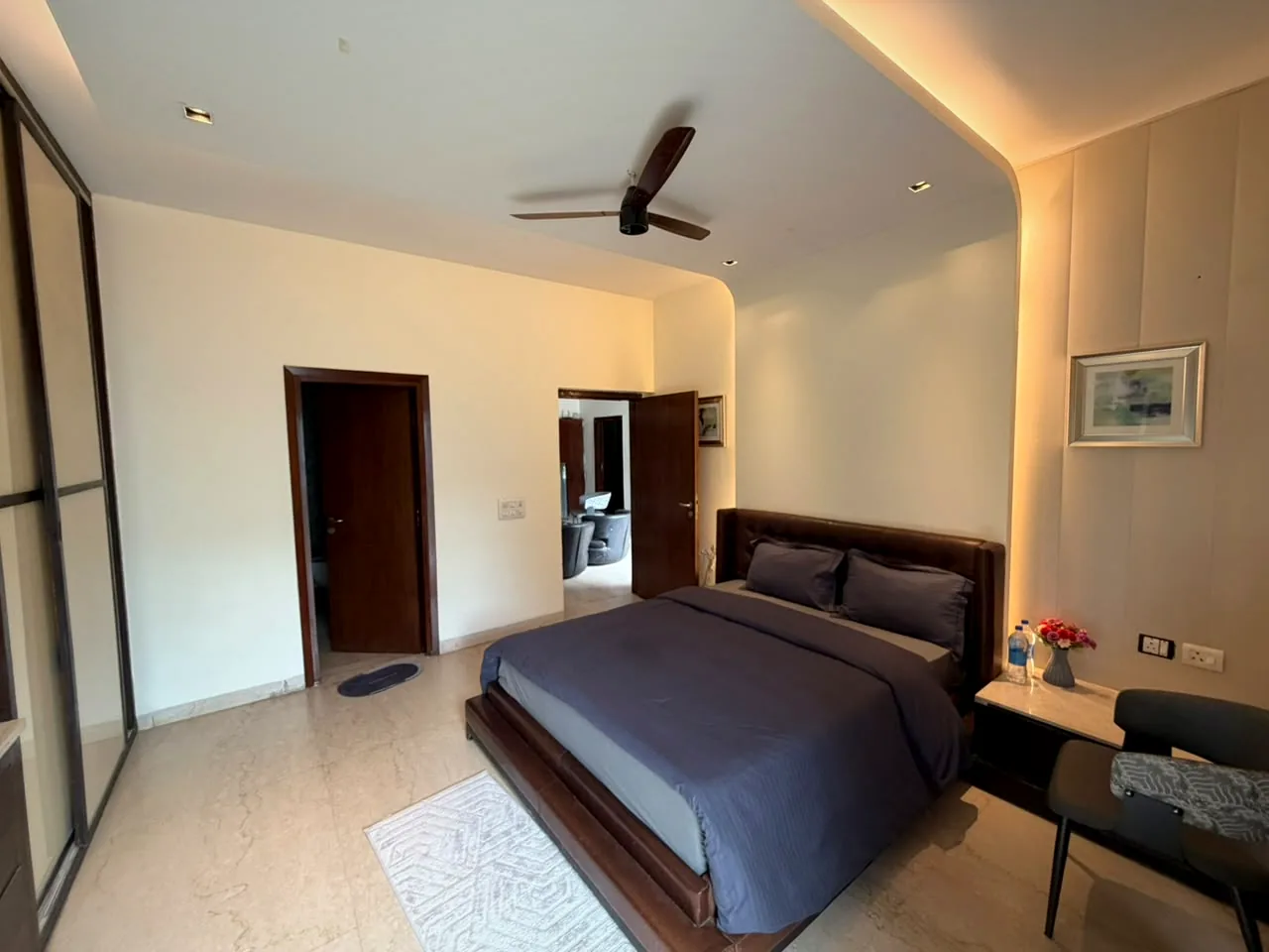 Bedroom with leather headboard and warm cove lighting at Nivasa Villas, Gurgaon