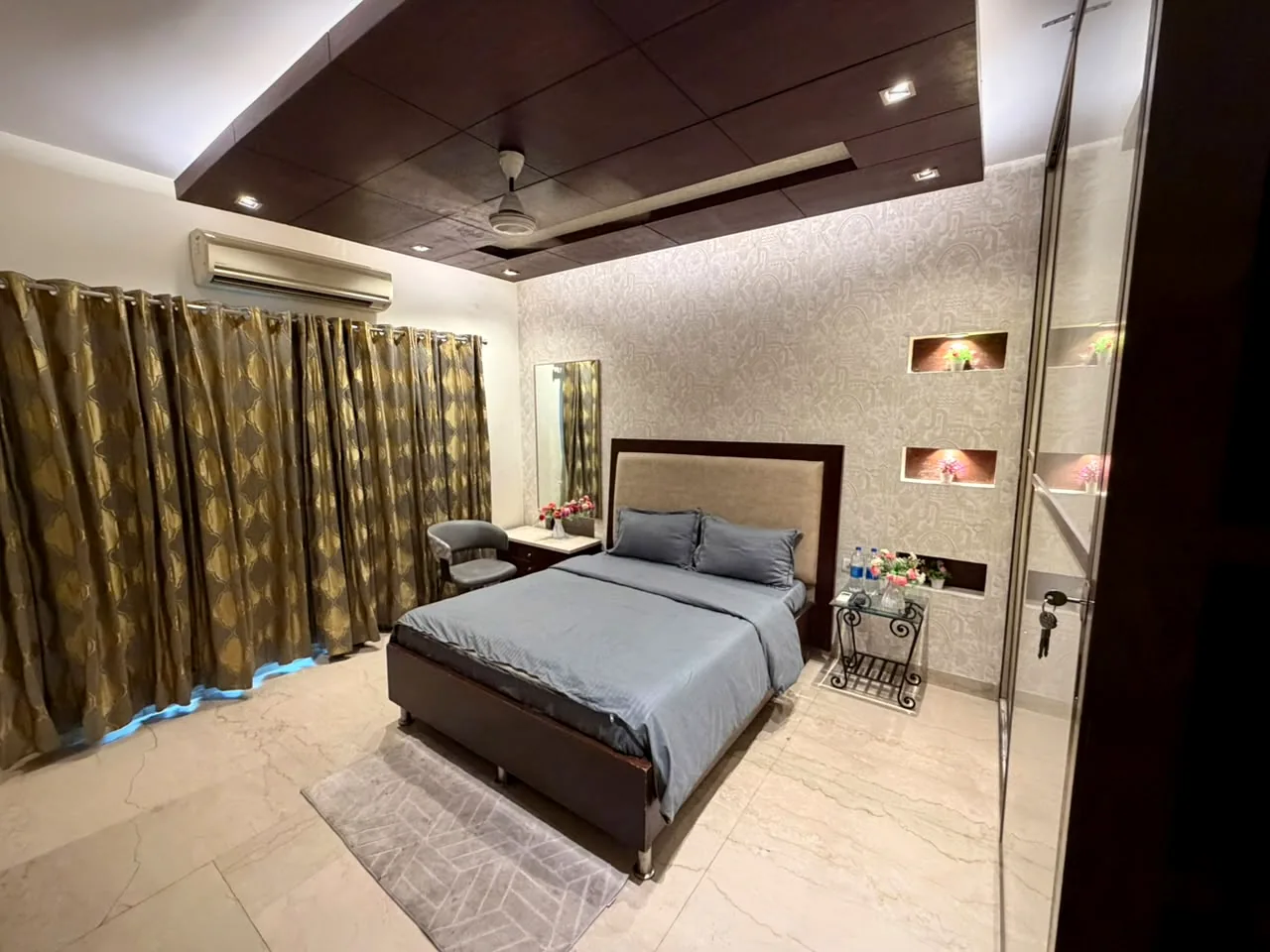 Bedroom with decorative wall niches and lattice door at Nivasa Villas, Gurgaon