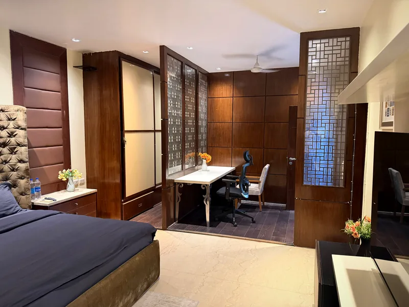 Bedroom with dedicated workspace nook behind wooden lattice screens at Nivasa Villas